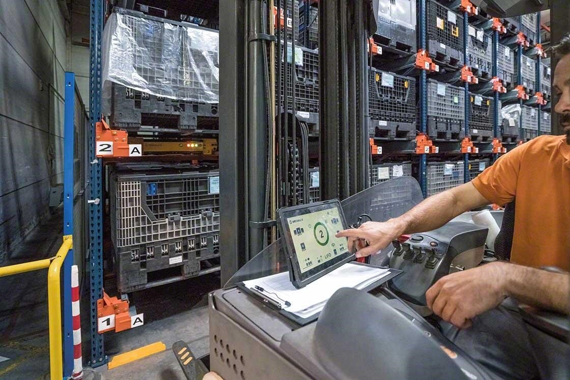 Un operatore che controlla i movimenti del Pallet Shuttle a bordo del carrello con un tablet Un operatore che controlla i movimenti del Pallet Shuttle a bordo del carrello con un tablet