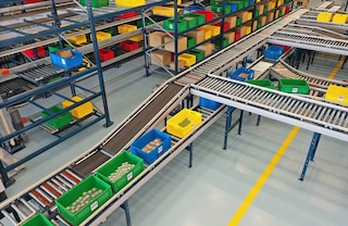 Un circuito di trasportatori per contenitori collega le scaffalature alle stazioni di picking 