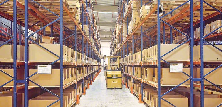 Operatore lavorando in corsia tra scaffalature convenzionali